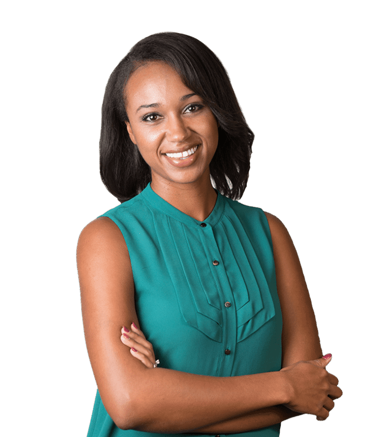 A woman with shoulder-length dark hair, wearing a sleeveless teal blouse, stands smiling with her arms crossed against a plain white background.