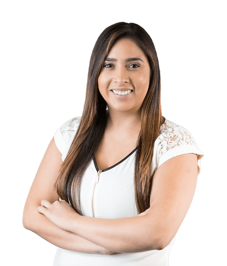 A woman with long brown hair wearing a white short-sleeve top stands with arms crossed, smiling at the camera against a plain white background.