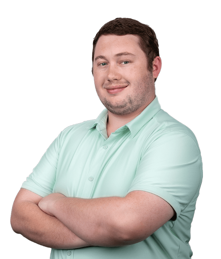 A man with short brown hair, wearing a light green collared shirt, stands with his arms crossed and smiles at the camera against a plain white background.